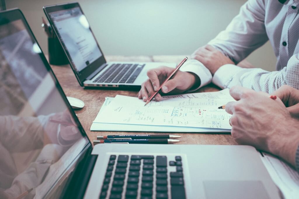 Zwei Arbeite am Laptop, die zusammen arbeiten